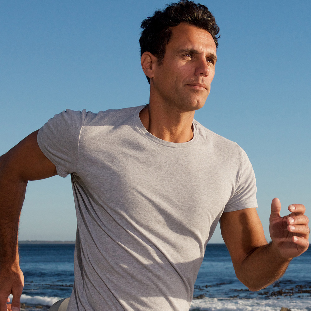 Middle-aged man running on the beach in good physical condition